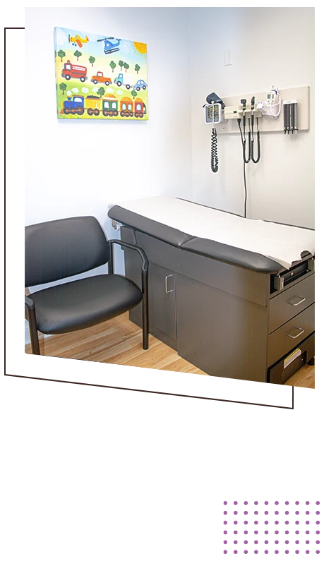 Pediatric exam room with an examination table, chair, wall-mounted medical equipment, and colorful transportation artwork.